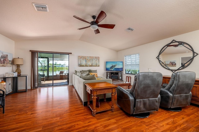 living room featuring hardwood / wood-style flooring, lofted ceiling, and a wealth of natural light