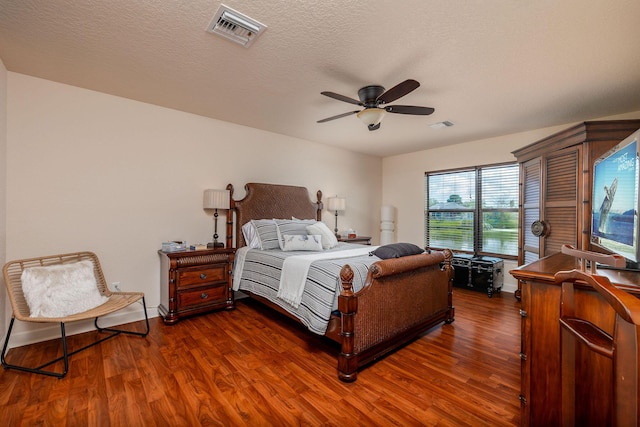 bedroom with dark wood-type flooring, ceiling fan, and a textured ceiling