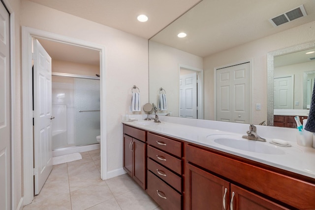 bathroom featuring tile patterned floors, vanity, toilet, and an enclosed shower