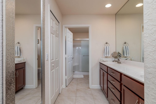 bathroom featuring vanity, toilet, tile patterned floors, and walk in shower