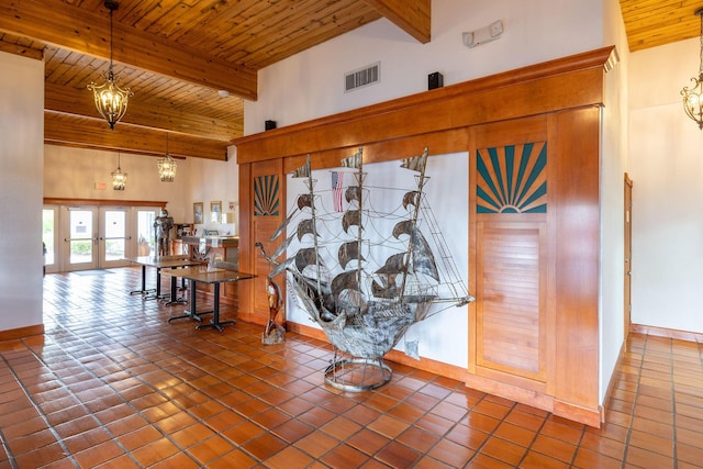 interior details featuring beamed ceiling, wood ceiling, french doors, and a notable chandelier