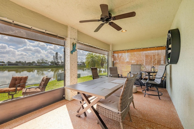 sunroom / solarium featuring a water view and ceiling fan