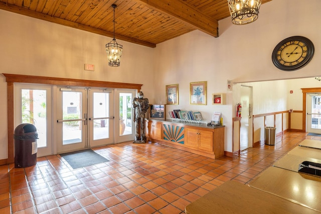 foyer featuring a high ceiling, a notable chandelier, wood ceiling, tile patterned floors, and french doors