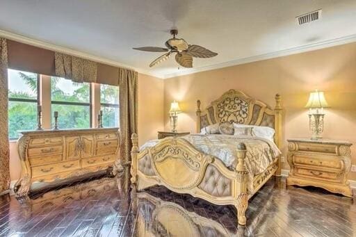 bedroom with dark wood-type flooring, ceiling fan, and ornamental molding