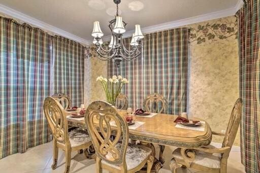 dining area featuring ornamental molding and an inviting chandelier