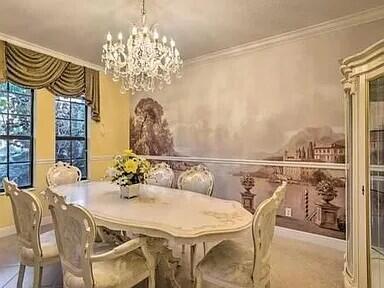 dining area featuring crown molding and a notable chandelier