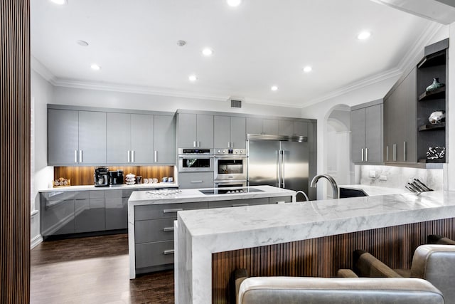 kitchen featuring open shelves, gray cabinetry, a peninsula, and appliances with stainless steel finishes