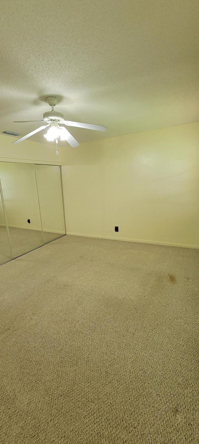 1747 W Royal Tern Ln Unit 1, Fort Pierce, FL 34982 - spare room featuring carpet, a textured ceiling, a ceiling fan, and baseboards
