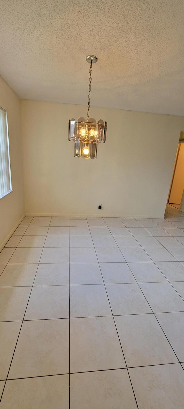 1747 W Royal Tern Ln Unit 1, Fort Pierce, FL 34982 - unfurnished room featuring a textured ceiling, a chandelier, and light tile patterned floors