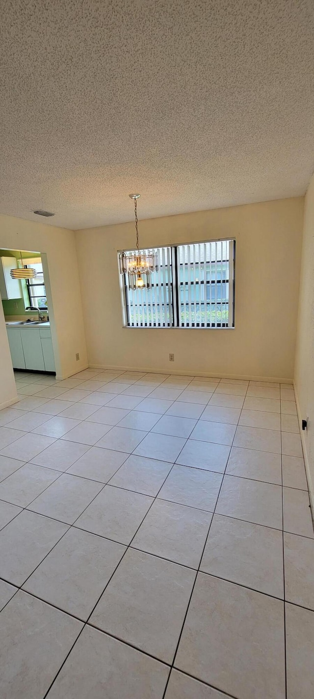 1747 W Royal Tern Ln Unit 1, Fort Pierce, FL 34982 - empty room featuring plenty of natural light, a textured ceiling, and light tile patterned flooring