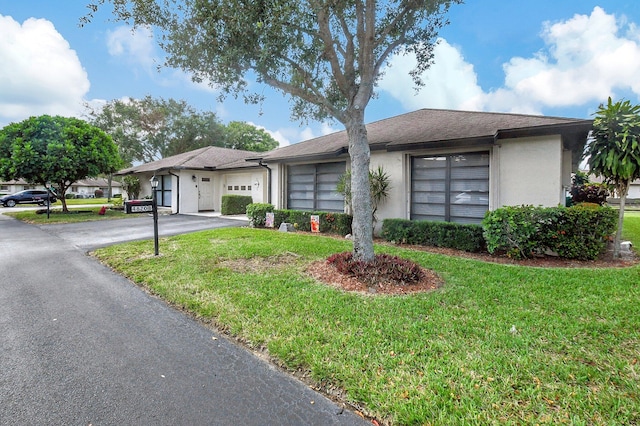 ranch-style house with a garage and a front yard