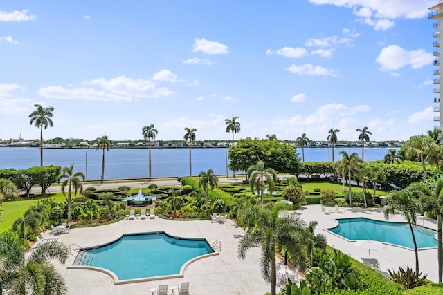 view of swimming pool featuring a patio and a water view