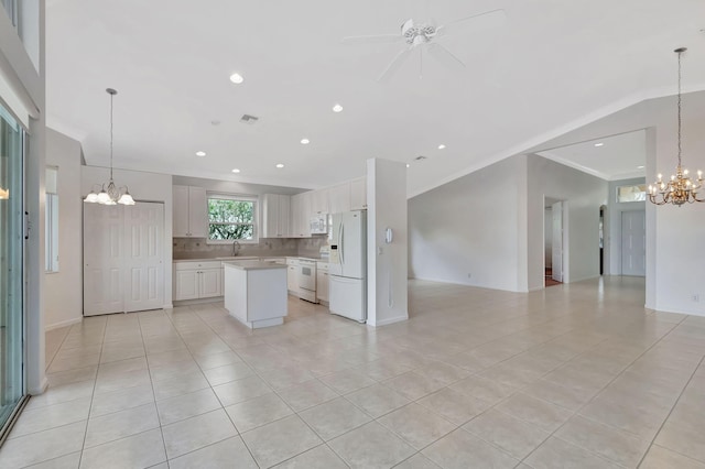 kitchen with white appliances, white cabinets, open floor plan, light countertops, and tasteful backsplash