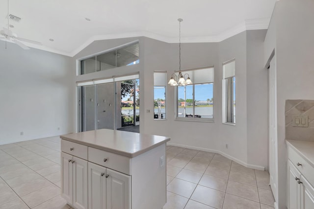 kitchen featuring light tile patterned floors, visible vents, white cabinets, and a center island