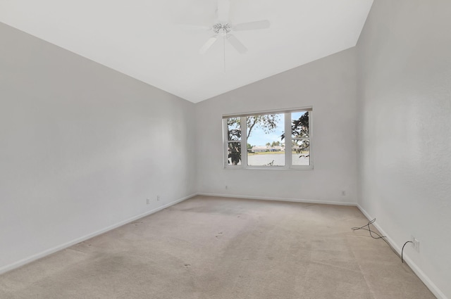 empty room with lofted ceiling, ceiling fan, light carpet, and baseboards