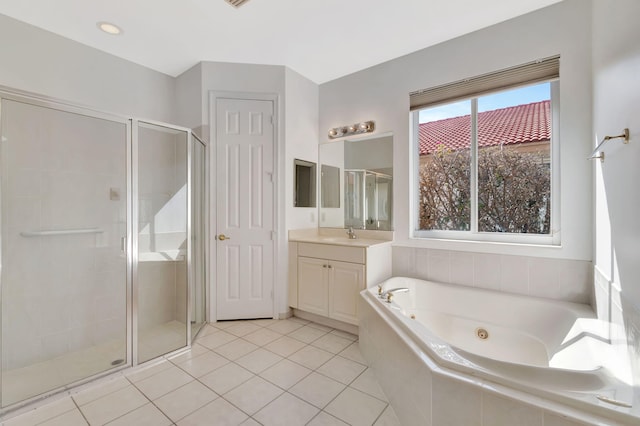 bathroom with a jetted tub, tile patterned flooring, a shower stall, and vanity