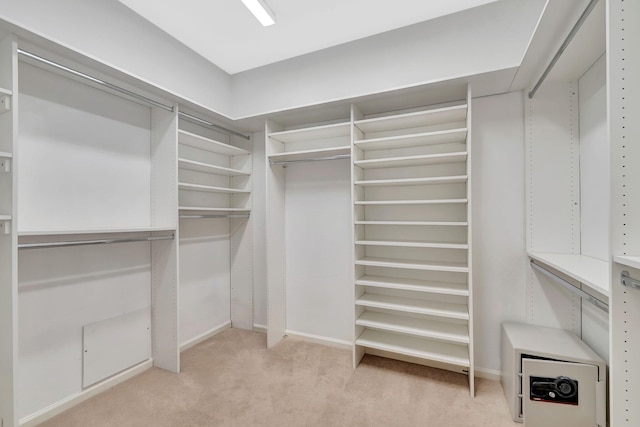 walk in closet featuring light carpet