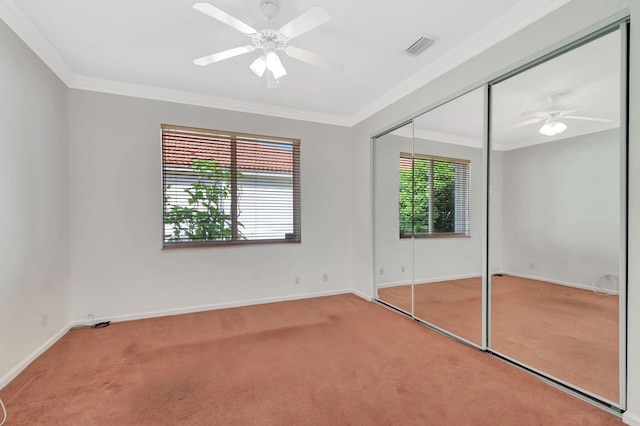 unfurnished bedroom with ornamental molding, a closet, carpet flooring, and baseboards