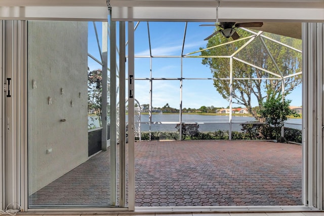 exterior space featuring a ceiling fan, a sunroom, and a water view