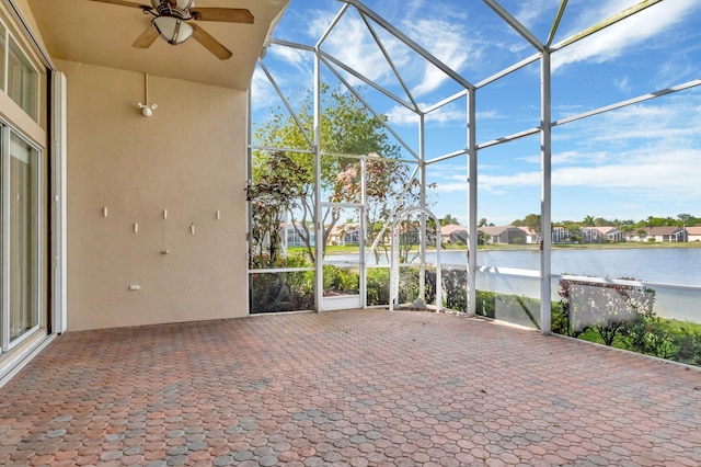 unfurnished sunroom featuring a water view and ceiling fan