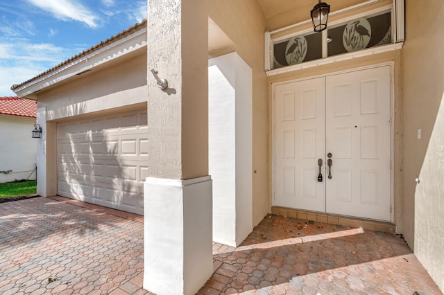 doorway to property with a tiled roof and stucco siding