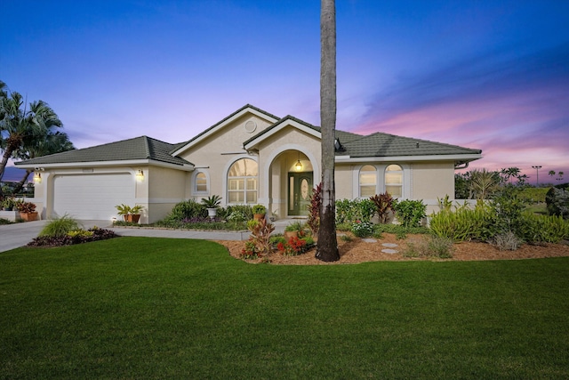 view of front of property with a yard and a garage