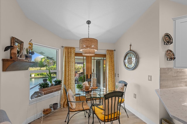 dining area featuring vaulted ceiling and light hardwood / wood-style floors