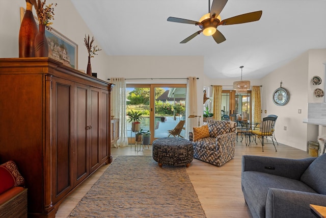 living room with ceiling fan, lofted ceiling, and light wood-type flooring