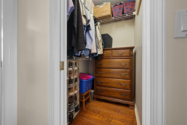 spacious closet with dark hardwood / wood-style flooring