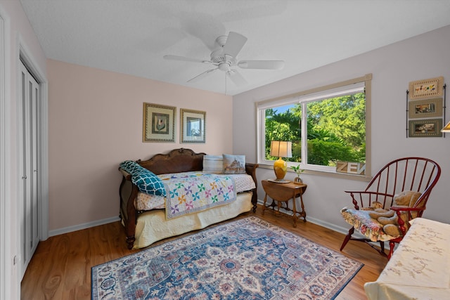 bedroom featuring hardwood / wood-style flooring, ceiling fan, and a closet