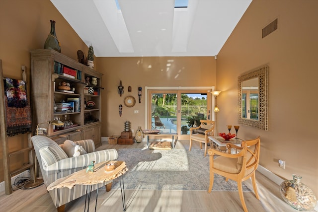 living area with high vaulted ceiling and light wood-type flooring