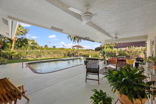 view of swimming pool featuring a patio and ceiling fan