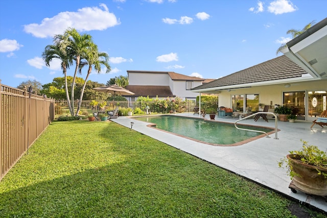 view of pool with a lawn and a patio