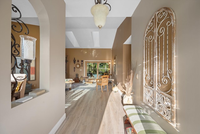 interior space with hardwood / wood-style flooring, vaulted ceiling, and radiator heating unit