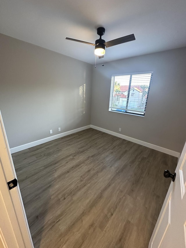 spare room featuring dark hardwood / wood-style flooring and ceiling fan