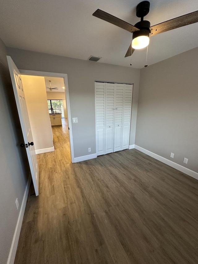 unfurnished bedroom with hardwood / wood-style floors, ceiling fan, and a closet