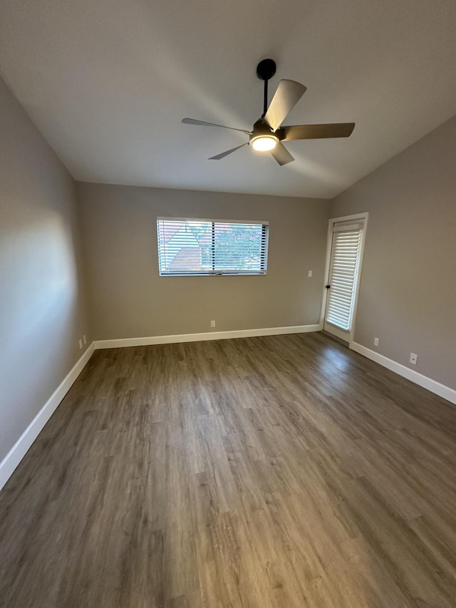 spare room featuring dark hardwood / wood-style flooring, lofted ceiling, and ceiling fan