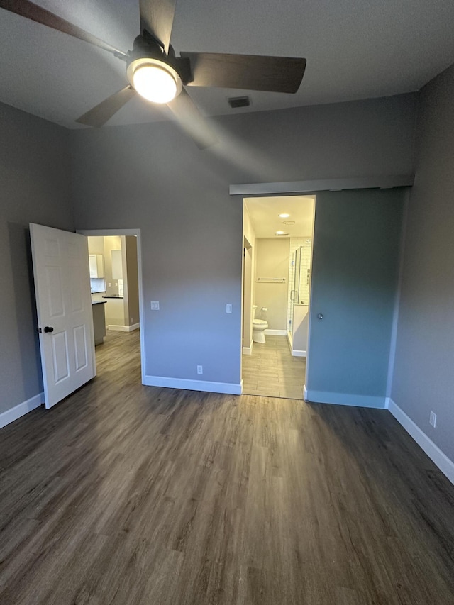 unfurnished bedroom featuring hardwood / wood-style flooring, ceiling fan, and ensuite bathroom