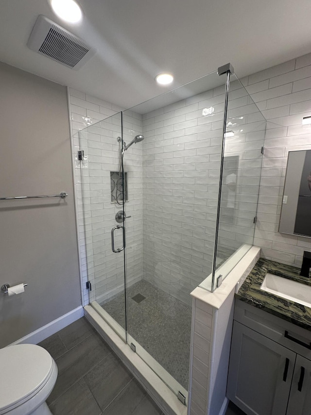 bathroom featuring vanity, an enclosed shower, and toilet