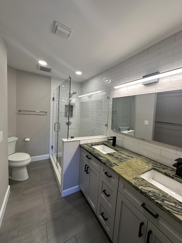 bathroom featuring toilet, vanity, an enclosed shower, and decorative backsplash