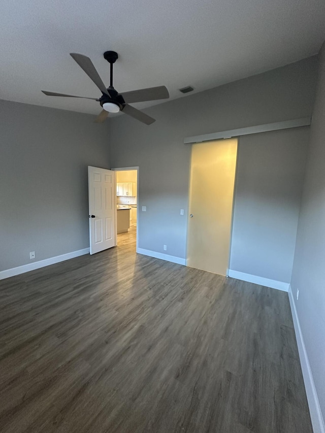 unfurnished bedroom featuring ceiling fan, dark hardwood / wood-style flooring, and a closet