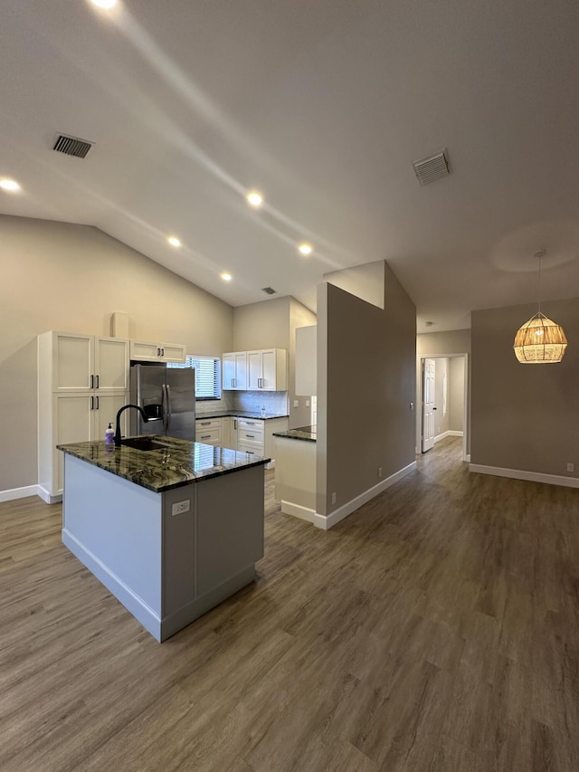 kitchen featuring dark wood-type flooring, decorative light fixtures, stainless steel fridge with ice dispenser, and white cabinets