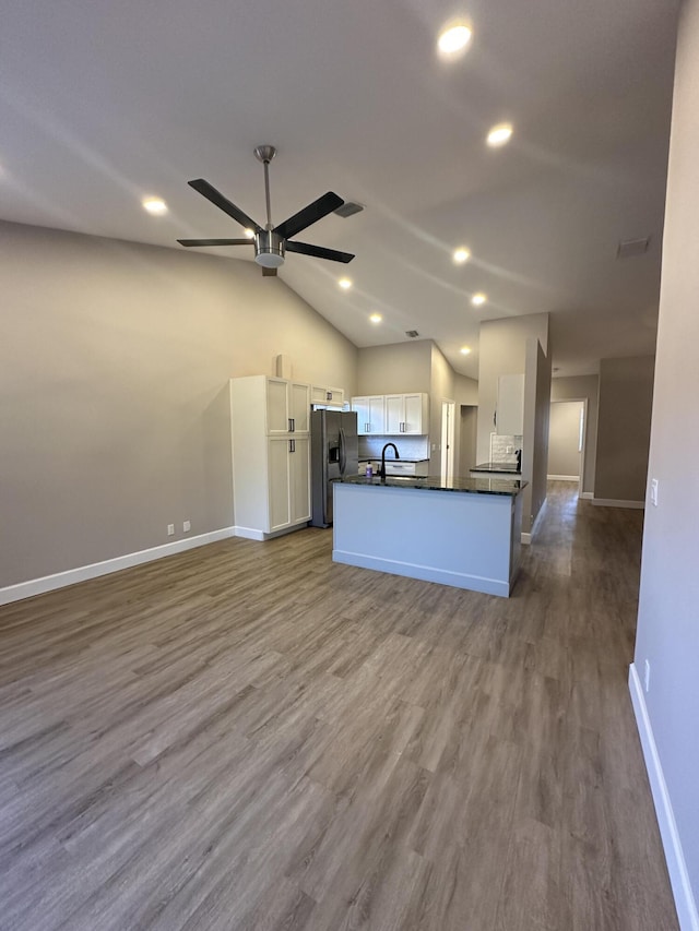 kitchen featuring white cabinetry, lofted ceiling, stainless steel fridge, ceiling fan, and light wood-type flooring