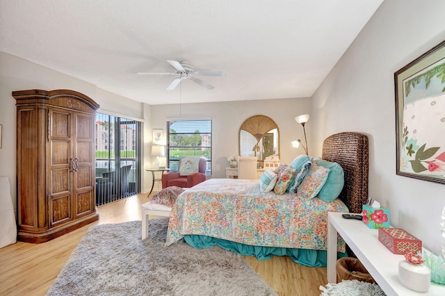 bedroom with light wood finished floors, access to outside, and ceiling fan