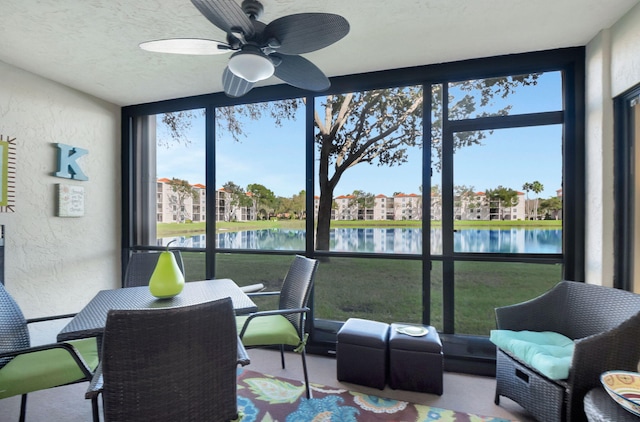 sunroom / solarium with a water view and a ceiling fan