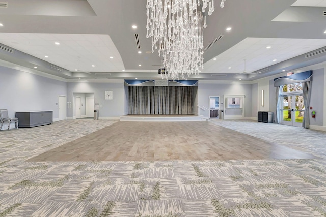 unfurnished living room with visible vents, a raised ceiling, carpet flooring, and recessed lighting