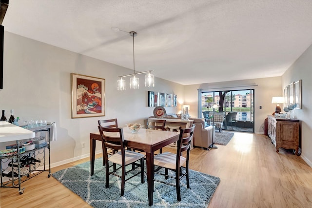 dining space with baseboards and wood finished floors