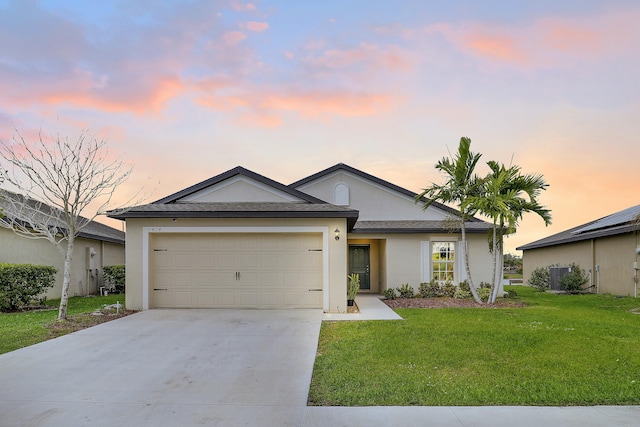 ranch-style home featuring an attached garage, a front lawn, concrete driveway, and stucco siding