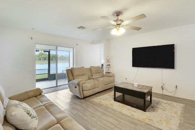 living area with light wood-style floors, visible vents, and a ceiling fan