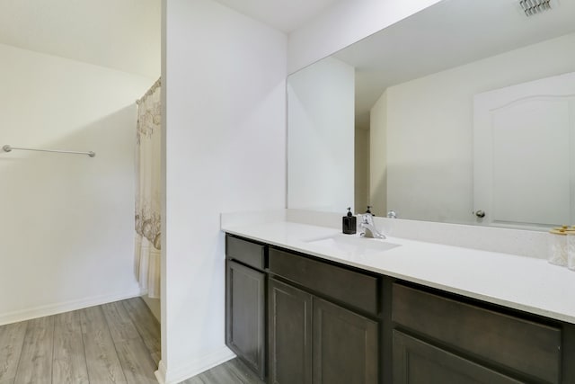 full bathroom with vanity, wood finished floors, visible vents, and baseboards